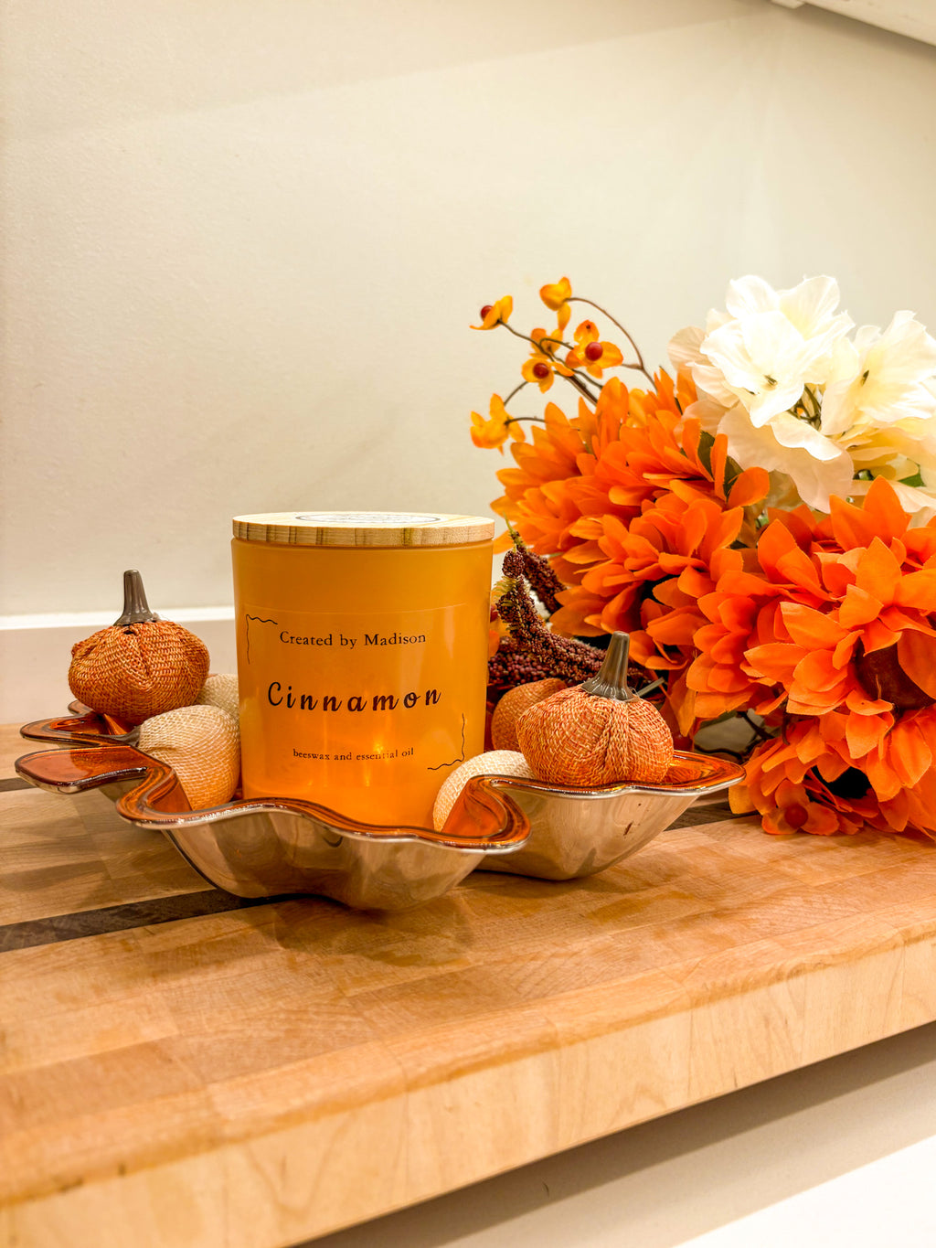 Cinnamon beeswax candle by Created by Madison in a decorative tray with pumpkins and fall flowers